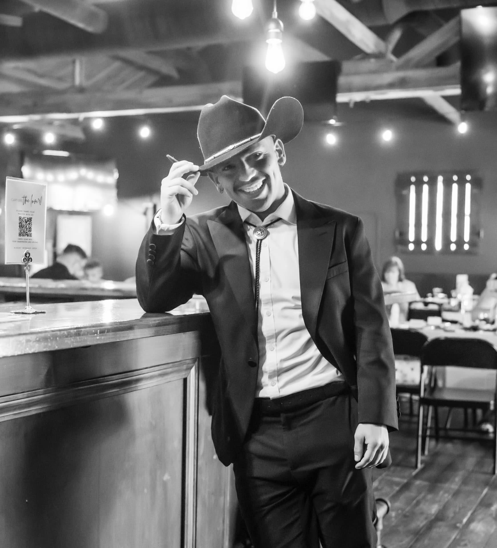 Adrian in a suit and cowboy hat at a Texas celebration